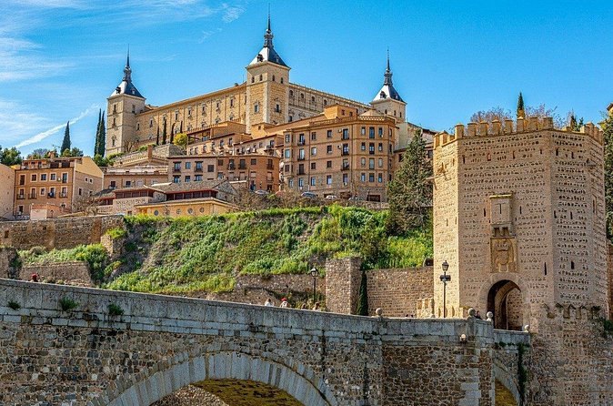 The Alcázar of Toledo above the medieval gate and stone arch of the Alcántara bridge