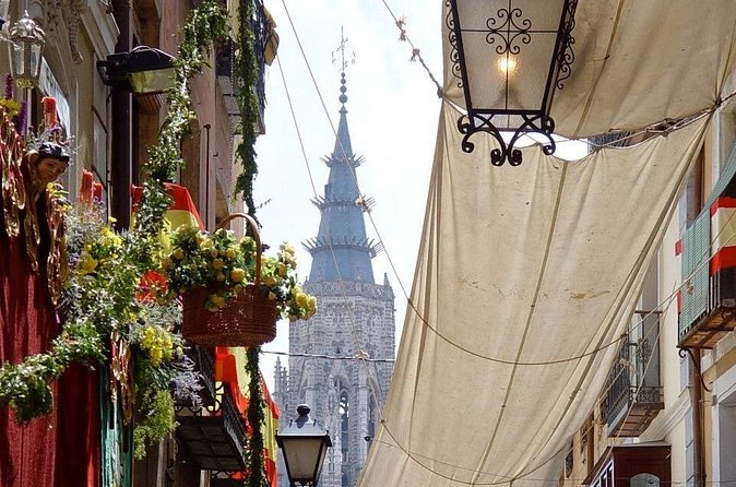 Cream awnings strung across a Toledo street and hung with garlands and tapestries for Corpus Christi