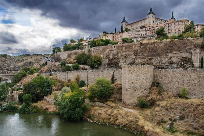 The Alcázar of Toledo standing on the rock above the Tagus gorge under a dark sky