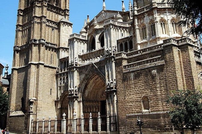 The west front of Toledo Cathedral with its single bell tower against a blue sky